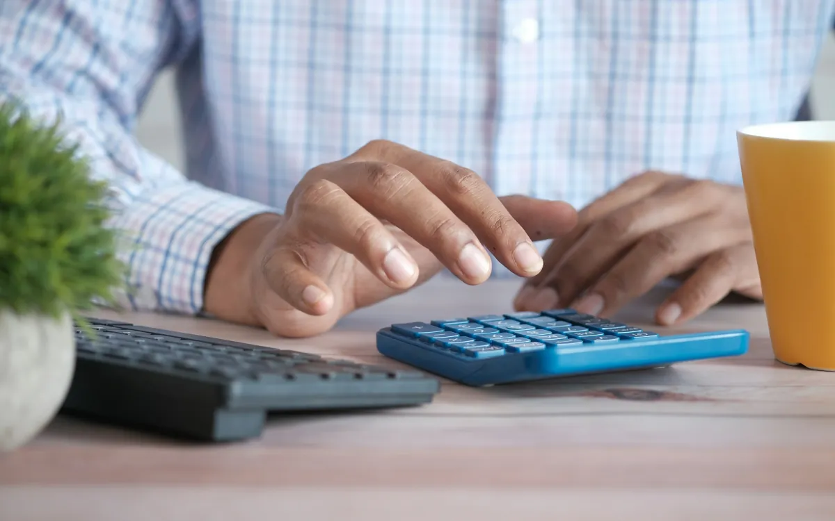 Mâini care calculează la calculator, la birou